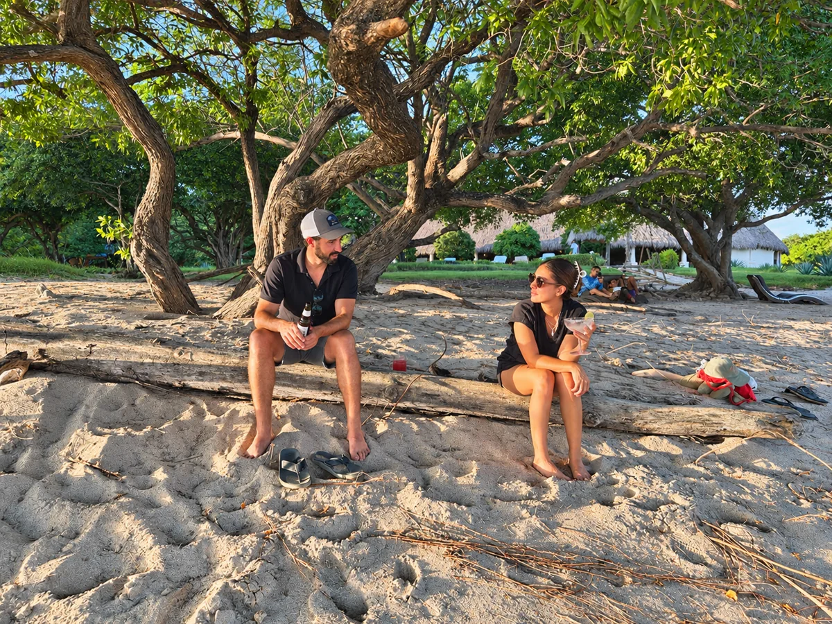 Guests relaxing in the shade by the beach