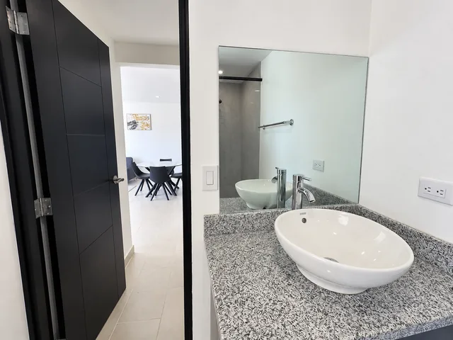 Bathroom vanity and mirror beside the living area