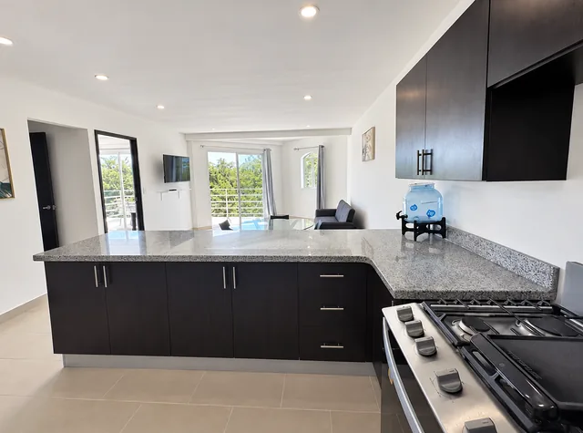 Kitchen with breakfast counter opening onto the living area