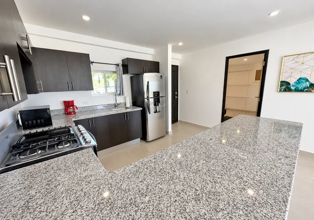Kitchen with stove, refrigerator and spacious countertop