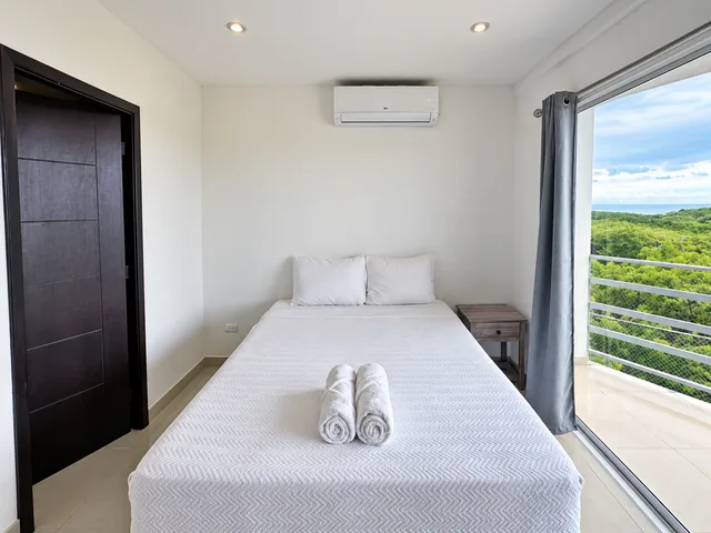 Air-conditioned bedroom with green coastal views