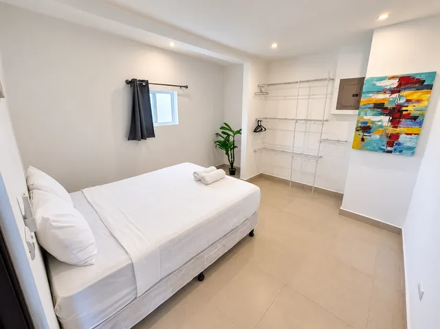 Guest bedroom with a wardrobe and colorful artwork