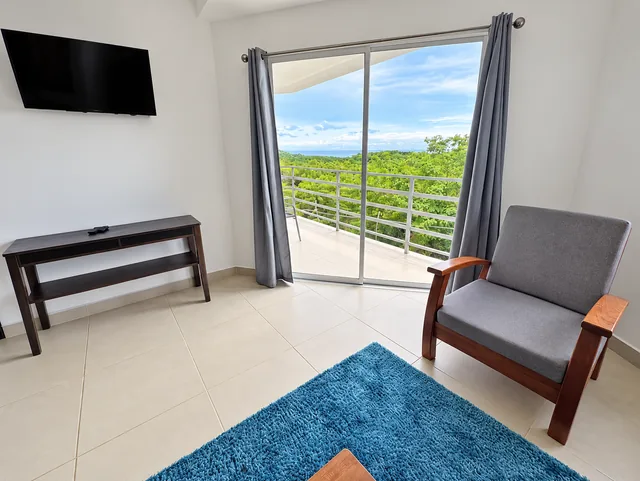 Lounge with television and sliding doors to the balcony