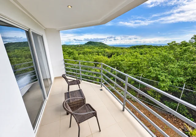 Private balcony overlooking tropical greenery and the Pacific
