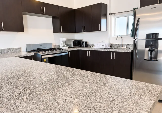 Kitchen with a breakfast counter, stove and refrigerator