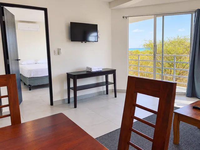 Living and dining area with balcony access and ocean views