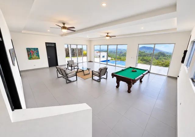 Downstairs lounge with a pool table and coastal views