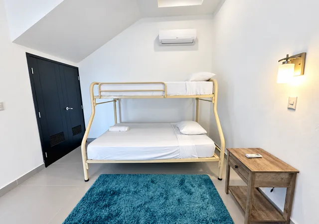 Guest room with bunk beds and a blue accent rug