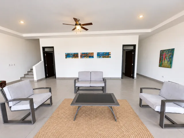 Downstairs sitting area with a television and ceiling fan