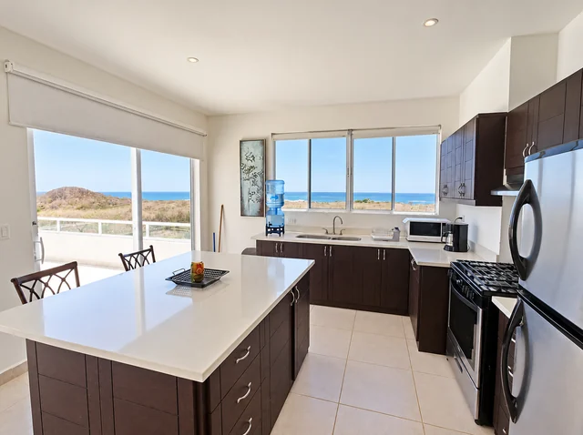 Ocean-view kitchen with breakfast island and balcony access
