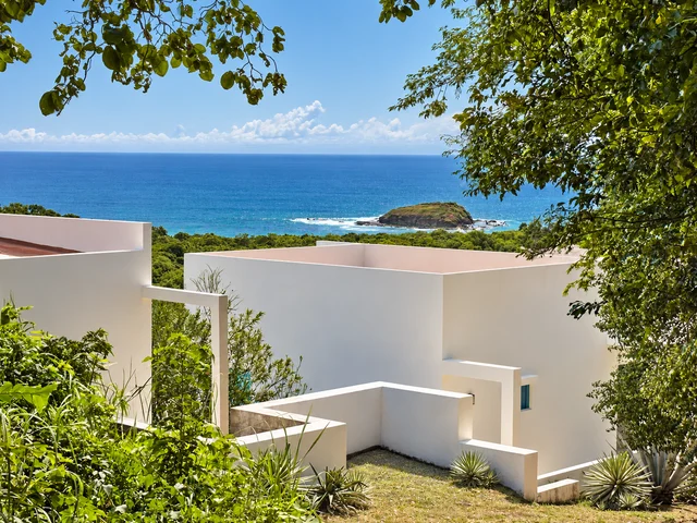 Ocean and island views beyond a hillside home